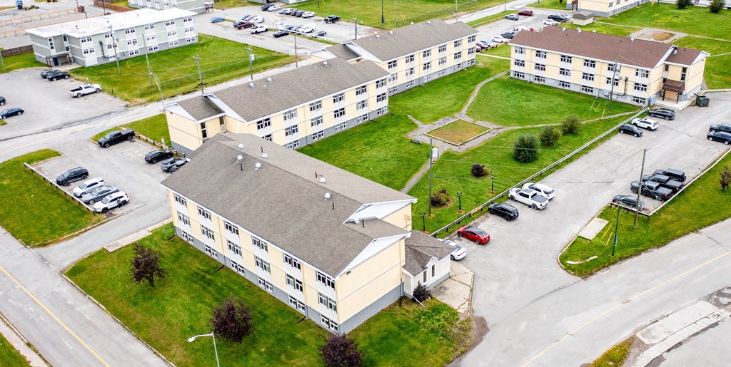 A large building with the word "SAN" on it is surrounded by a parking lot.