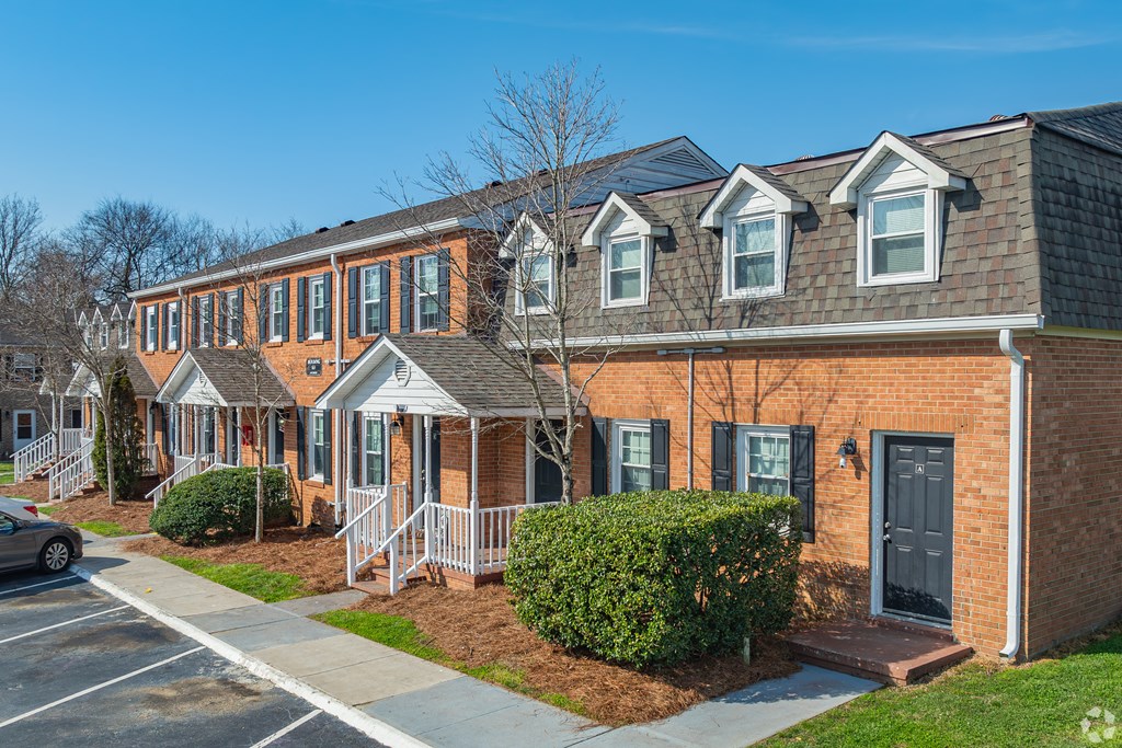 a row of brick apartment buildings on a sidewalk