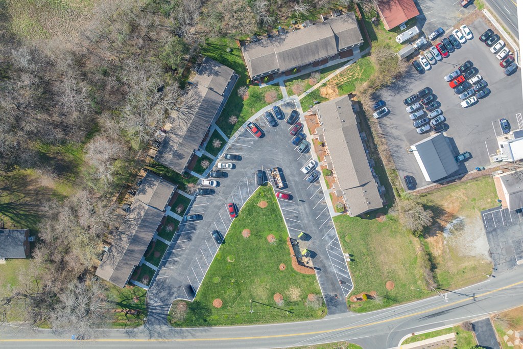 an aerial view of a parking lot with cars and a park