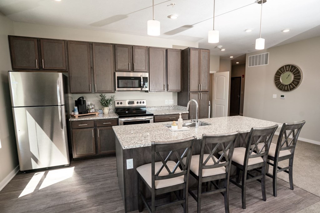 a kitchen with a large island and stainless steel appliances