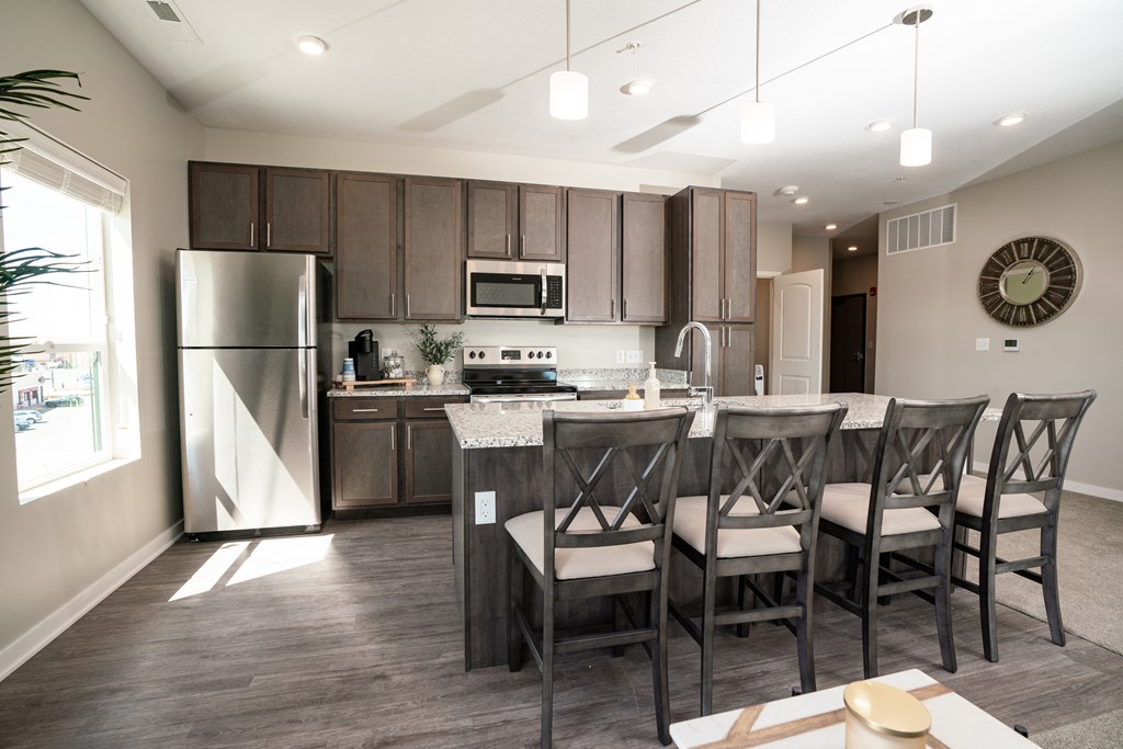 a kitchen with a large island with chairs and a table