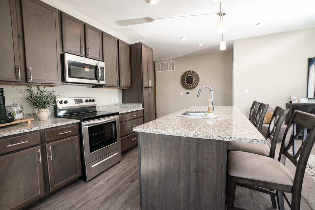 a kitchen with stainless steel appliances and a marble counter top