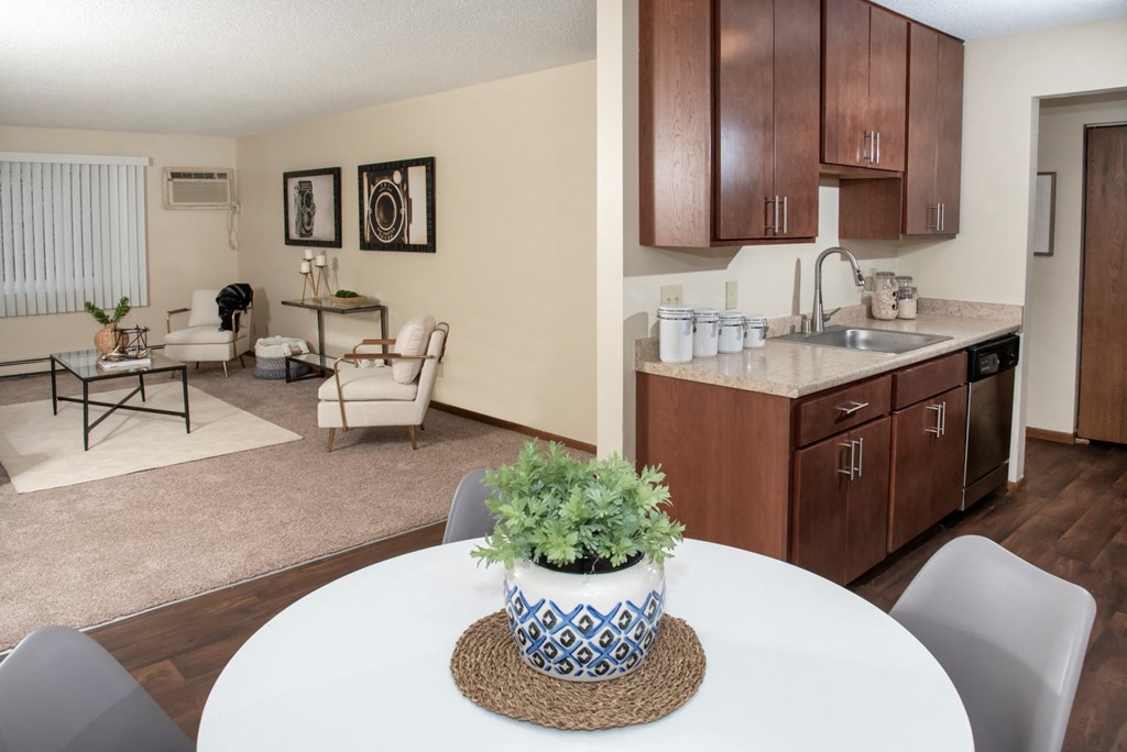 a dining room table with a vase on top of it next to a kitchen
