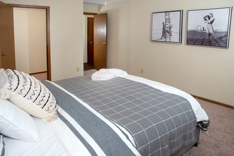 a bedroom with a bed and two pictures on the wall