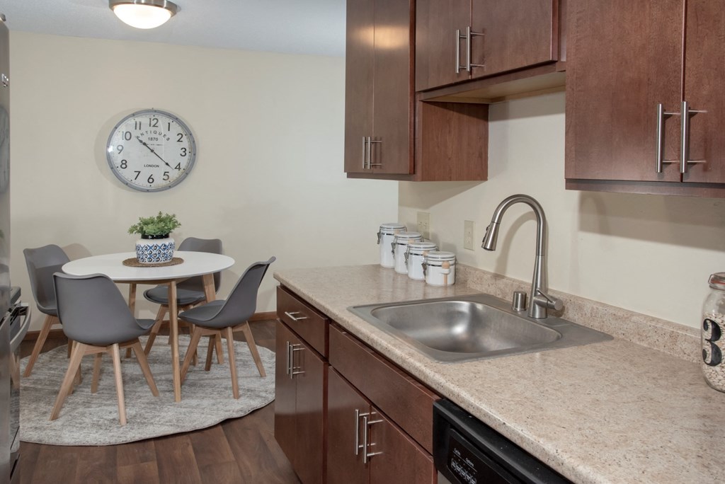 a kitchen with a sink and a table with chairs