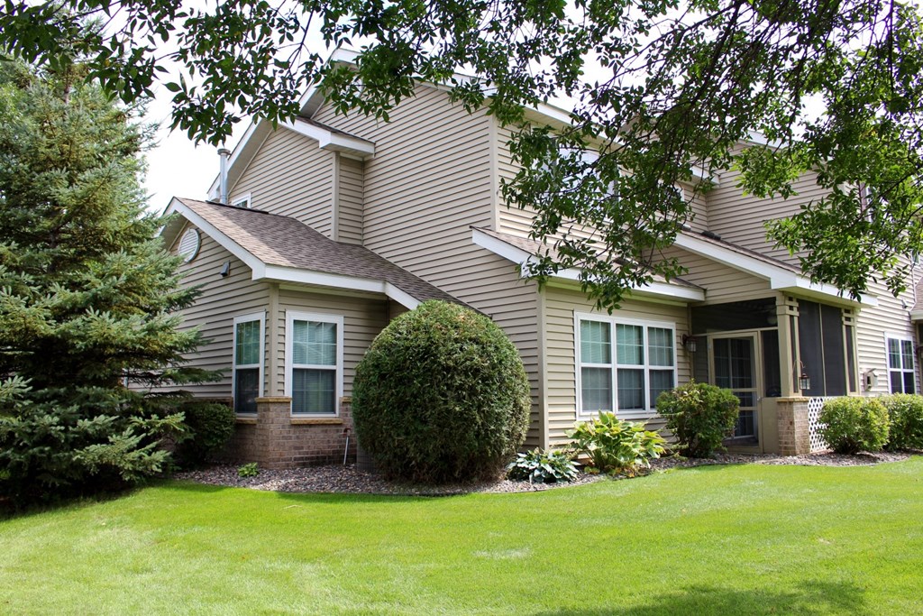exterior of townhome with screened in porch and landscaping