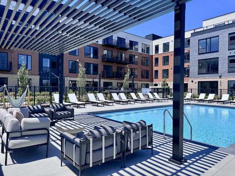 A pool area with sun loungers and a hammock.