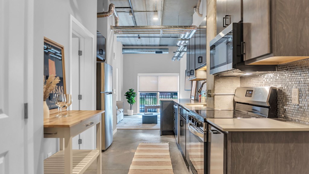A modern kitchen with a view of the balcony outside.