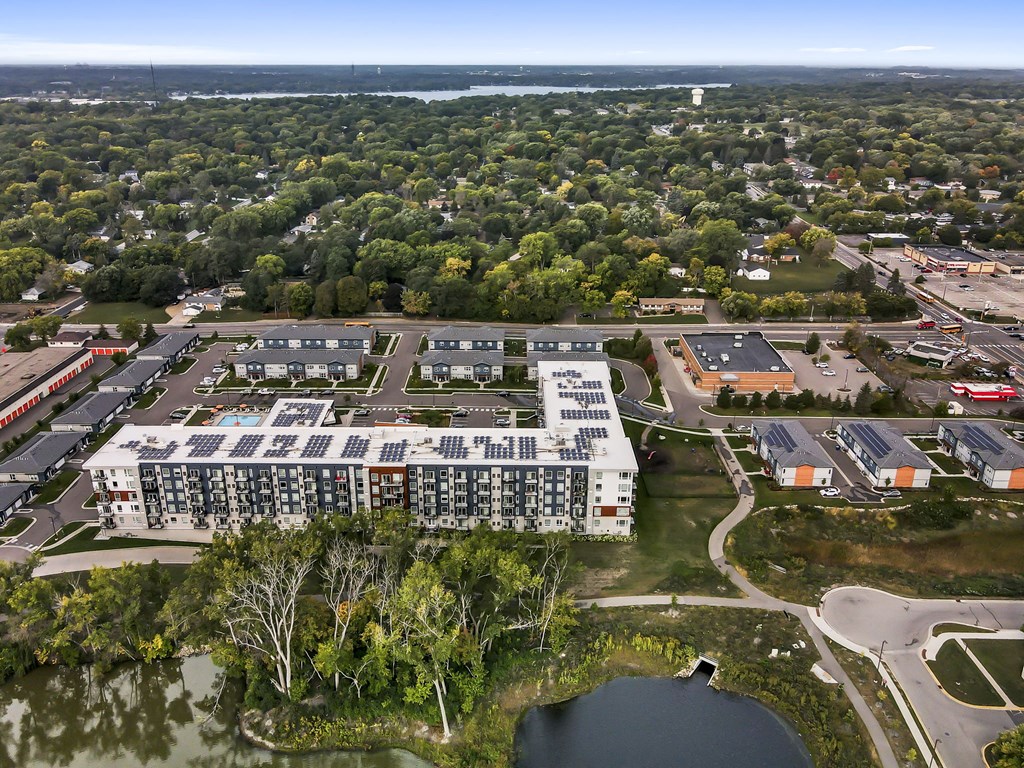 an aerial view of a large apartment complex with a lake in the background