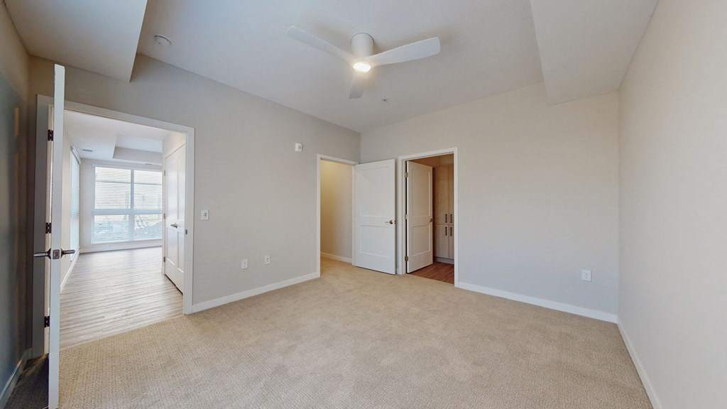 large empty primary bedroom with closet and private bath