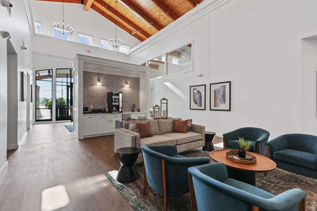 a living room with a vaulted ceiling and a kitchen in the background