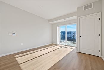 A room with a white door and a window with a view of a balcony at Lochner Apartments, White Bear Lake