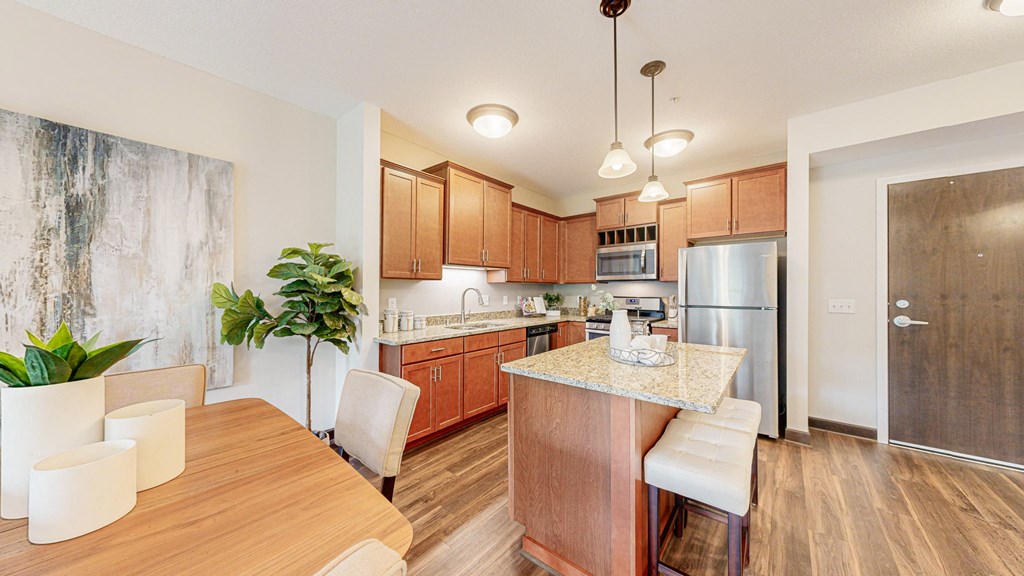 a kitchen with wooden cabinets and a table with chairs at Victoria Flats, Victoria, Minnesota