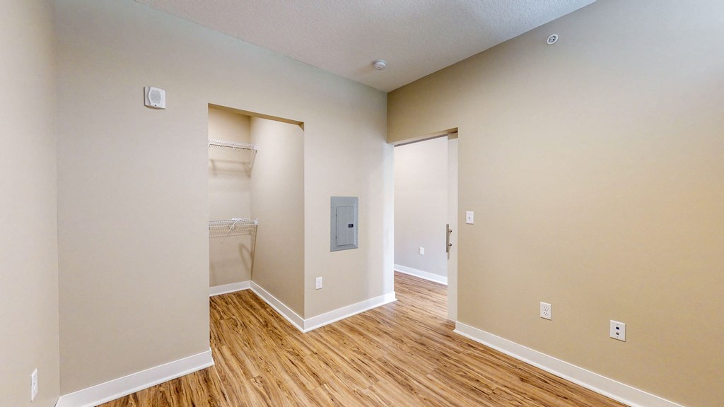 a renovated living room with wood flooring and a door to a bathroom
