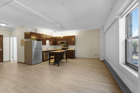 A kitchen with a refrigerator, stove, and sink.