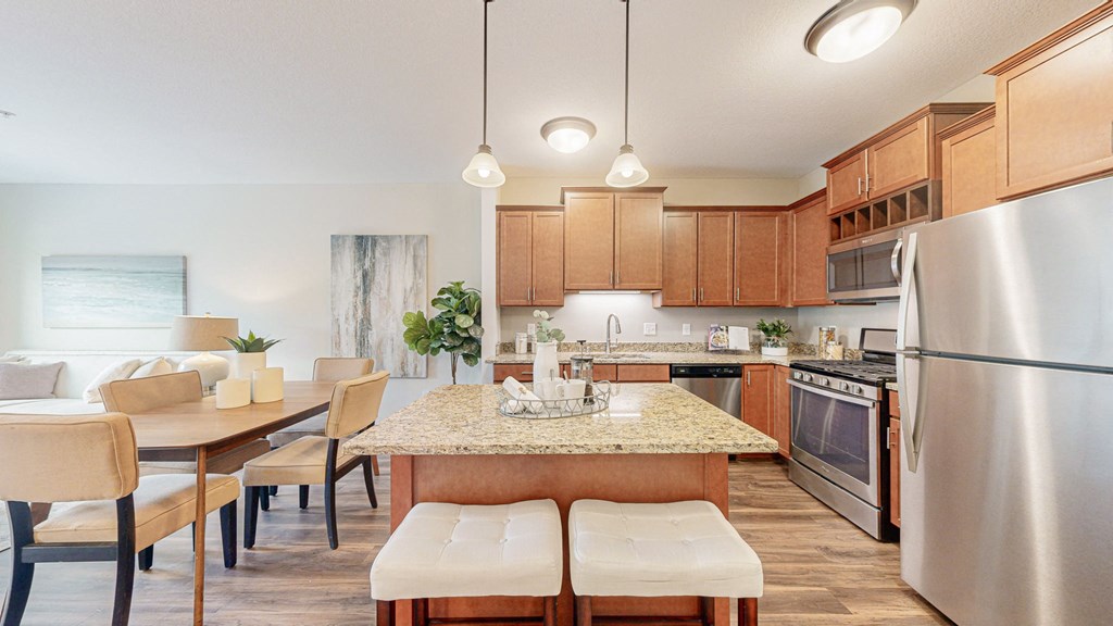 a kitchen and dining room with wood cabinets and stainless steel appliances at Victoria Flats, Victoria, 55386