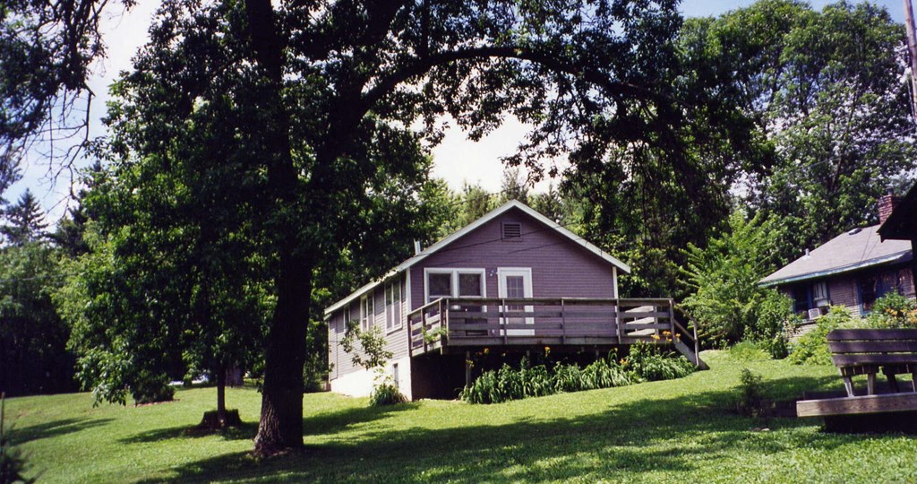a house on a hill with a deck and a tree