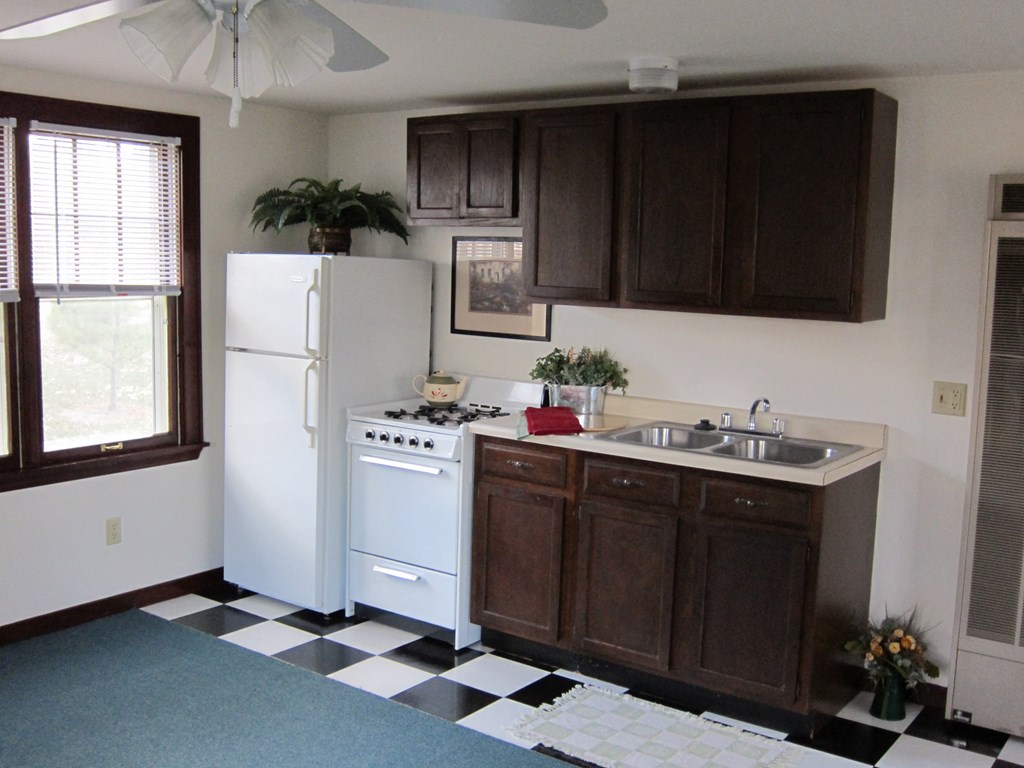 a kitchen with white appliances and a checkered floor
