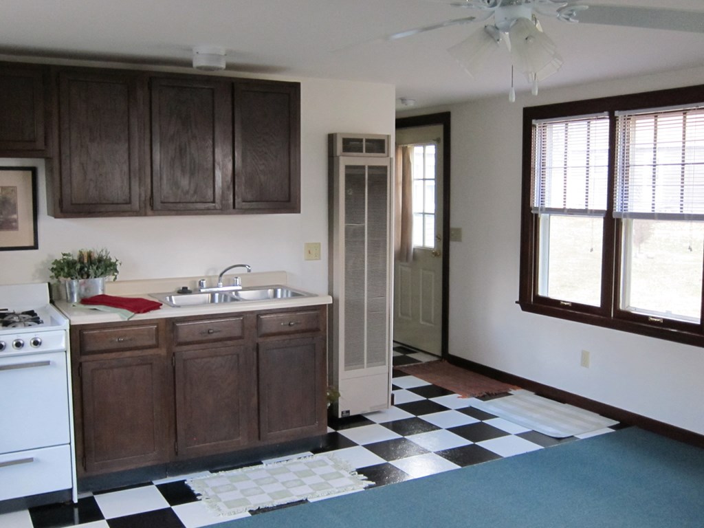a kitchen with a black and white checkered floor and a stove and sink
