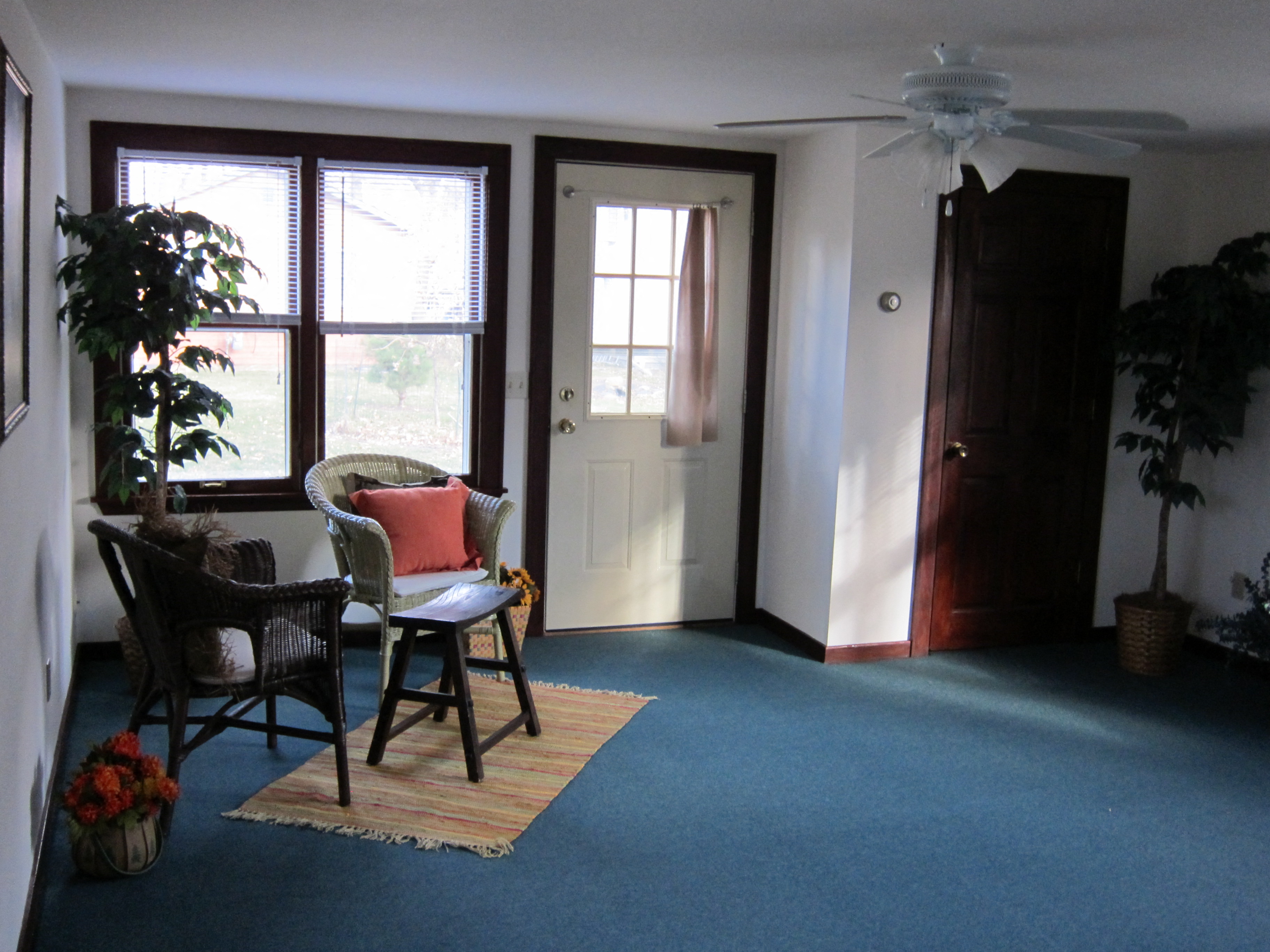 a living room with a table and chairs and a ceiling fan