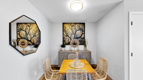 A dining room with a wooden table and chairs.