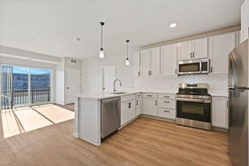 A modern kitchen with stainless steel appliances and white cabinets at Lochner Apartments, Minnesota, 55110