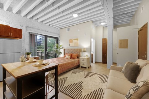 A well-lit, spacious bedroom with a large bed and a dining table.