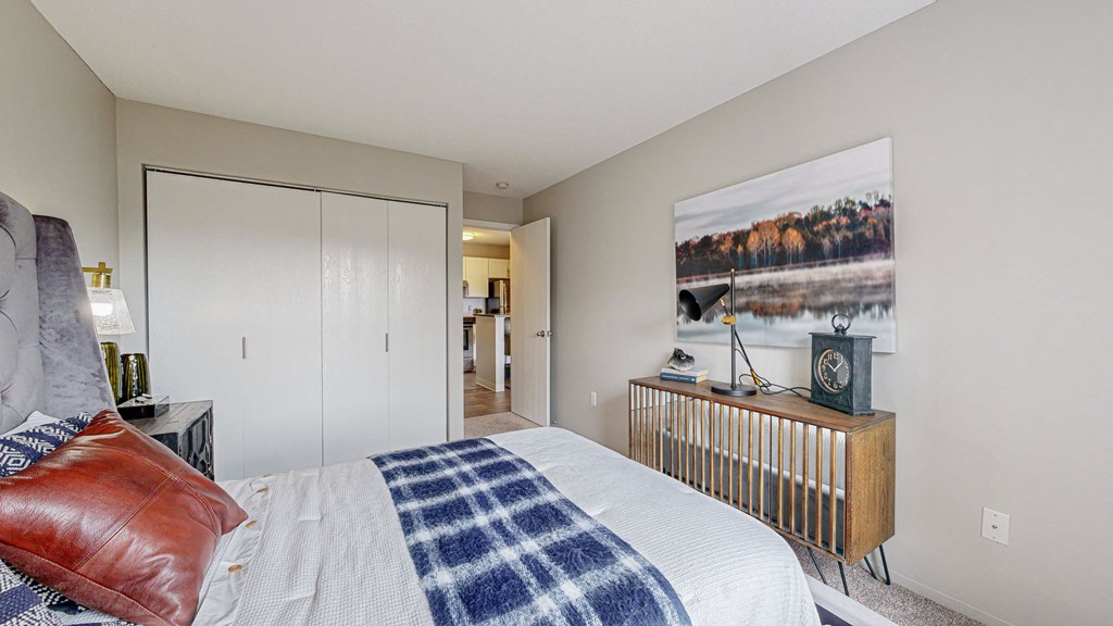 a bedroom with a bed and a painting on the wall