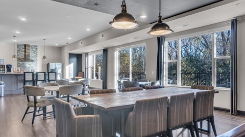 A modern dining room with a long table and chairs.