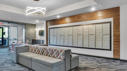 A modern office space with a grey sofa and a wooden accent wall.