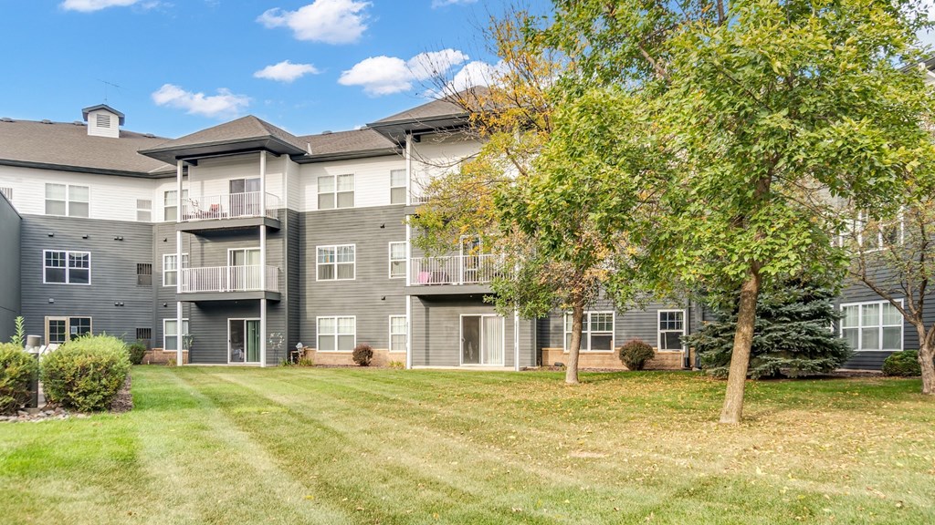 A large apartment complex with a green lawn in front.
