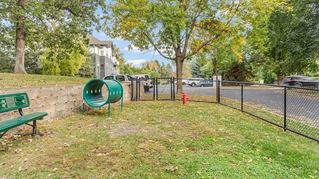 A green park bench sits in the foreground of a grassy area.