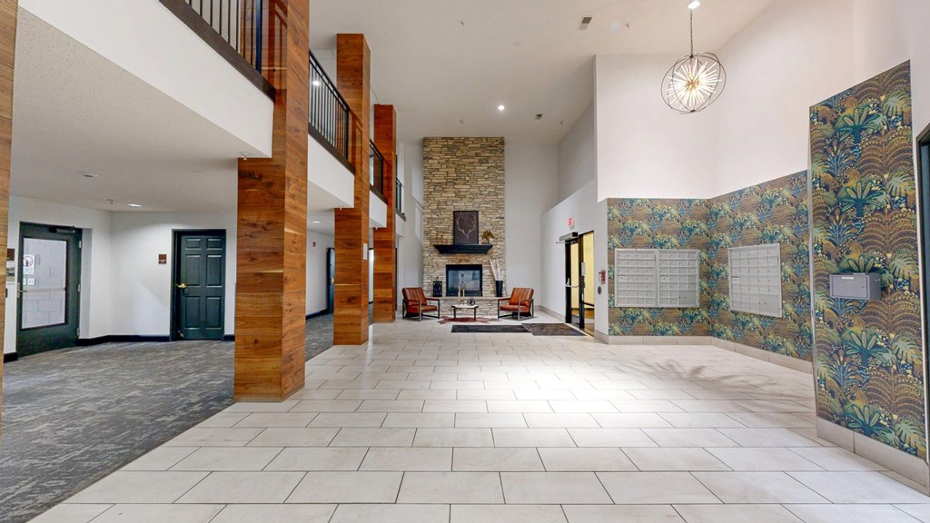 A spacious lobby with a staircase and a wall mural.
