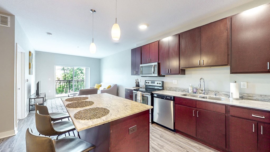 a kitchen with wooden cabinets and a marble counter top