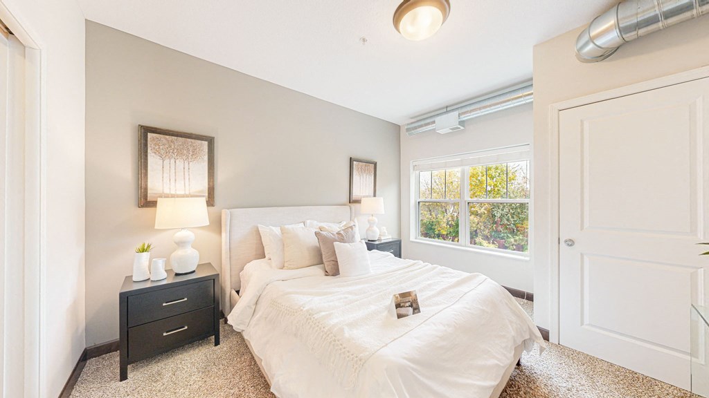 a bedroom with a large bed and a window