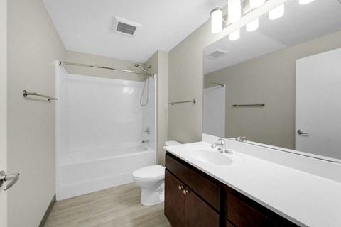A white bathroom with a toilet, sink, and shower.