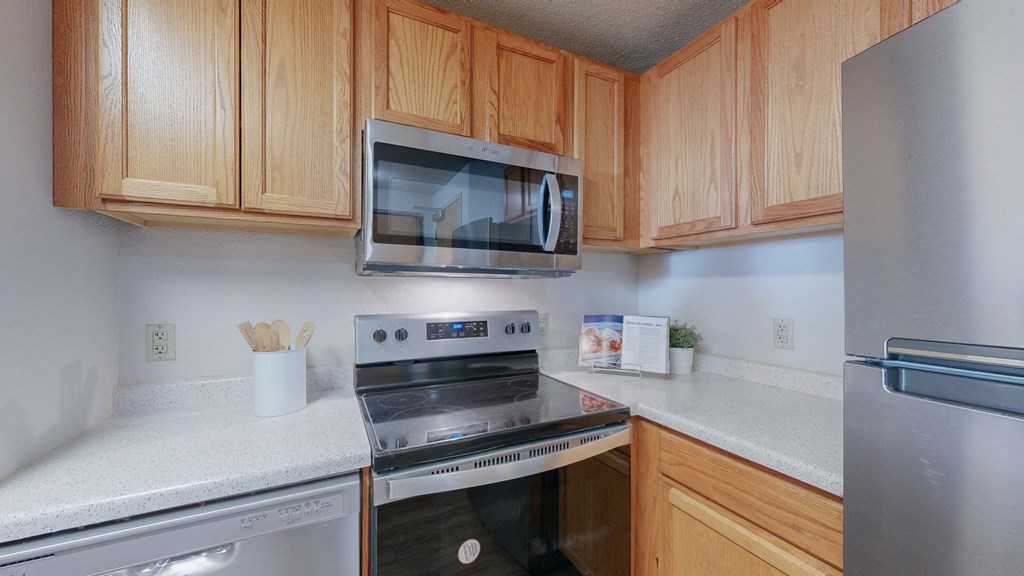 a kitchen with oak cabinets and stainless steel appliances at Bierman Place, Minneapolis, MN