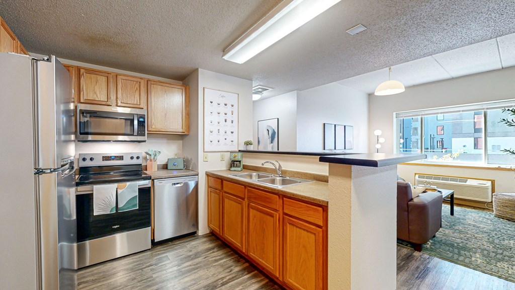 a kitchen with stainless steel appliances and wooden cabinets at Bierman Place, Minneapolis, MN, 55414