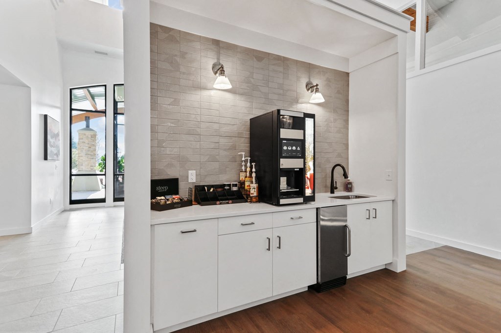 a kitchen with white cabinets and a black coffeemaker