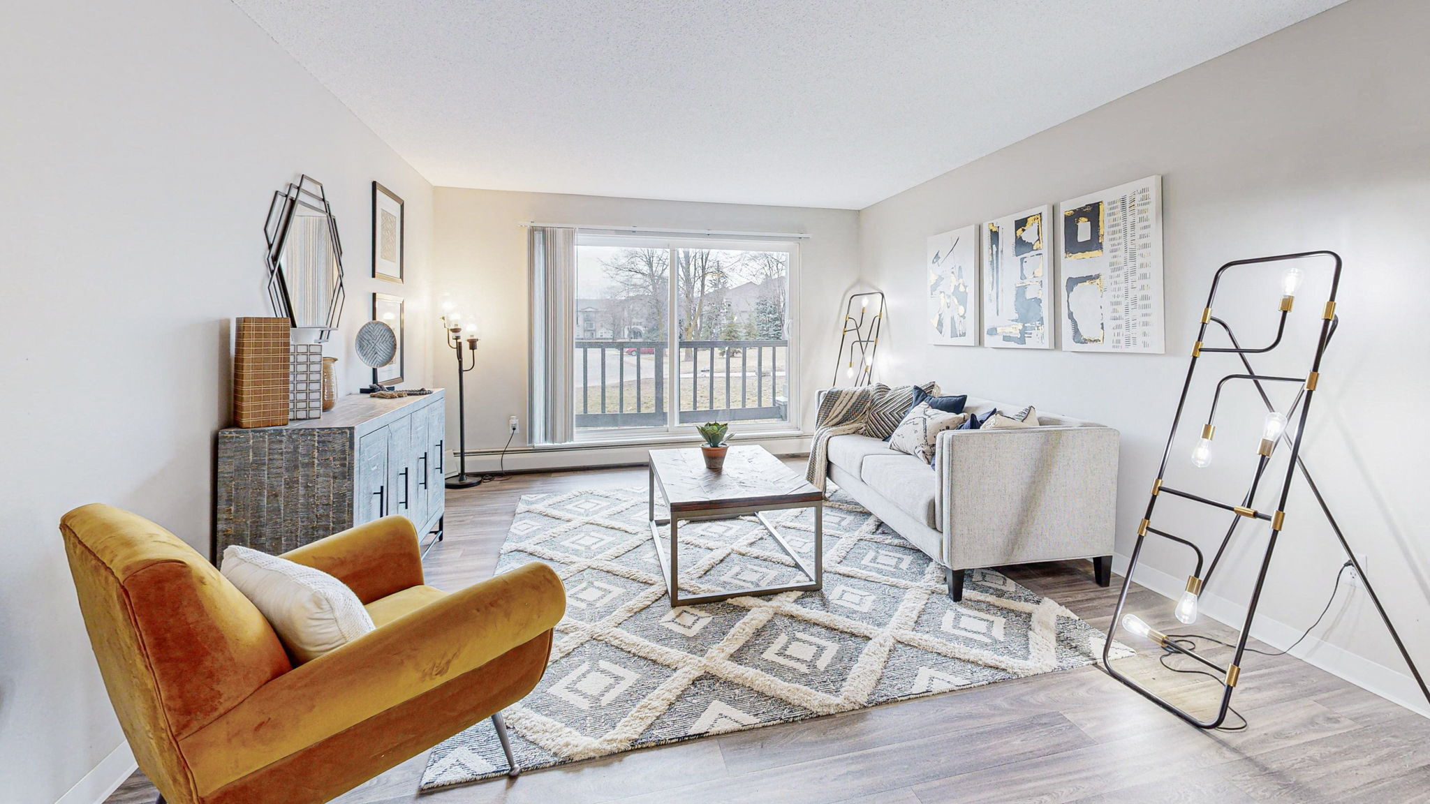 a living room with a couch and a chair and a window