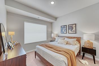 A bedroom with a large bed and a nightstand with a lamp at Lochner Apartments, Minnesota