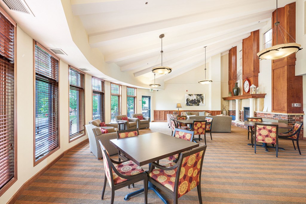 a large room with tables and chairs and windows