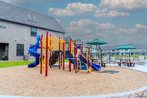 A playground with a blue slide and red and yellow play structures.