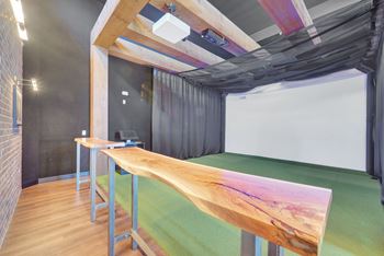 A room with a long wooden table and a white screen on the wall.