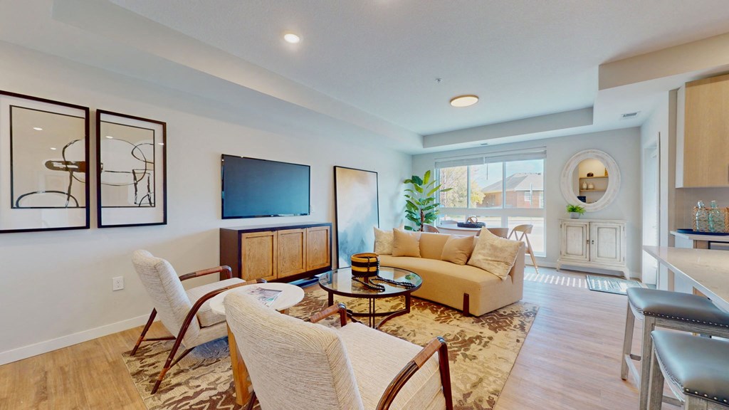 a living room with a couch and chairs and a tv