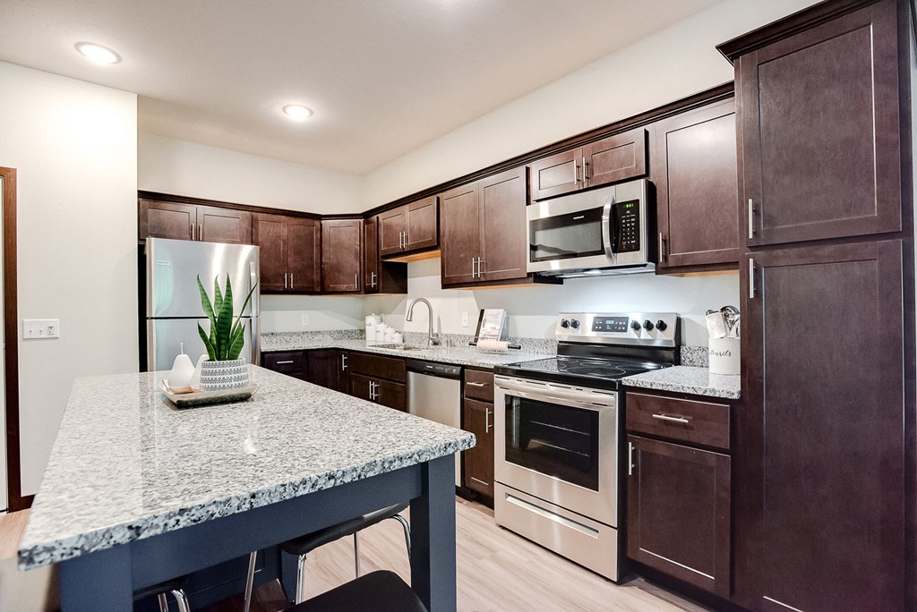 kitchen with espresso cabinetry and accent island at Lake Jonathan Flats, Chaska, Minnesota
