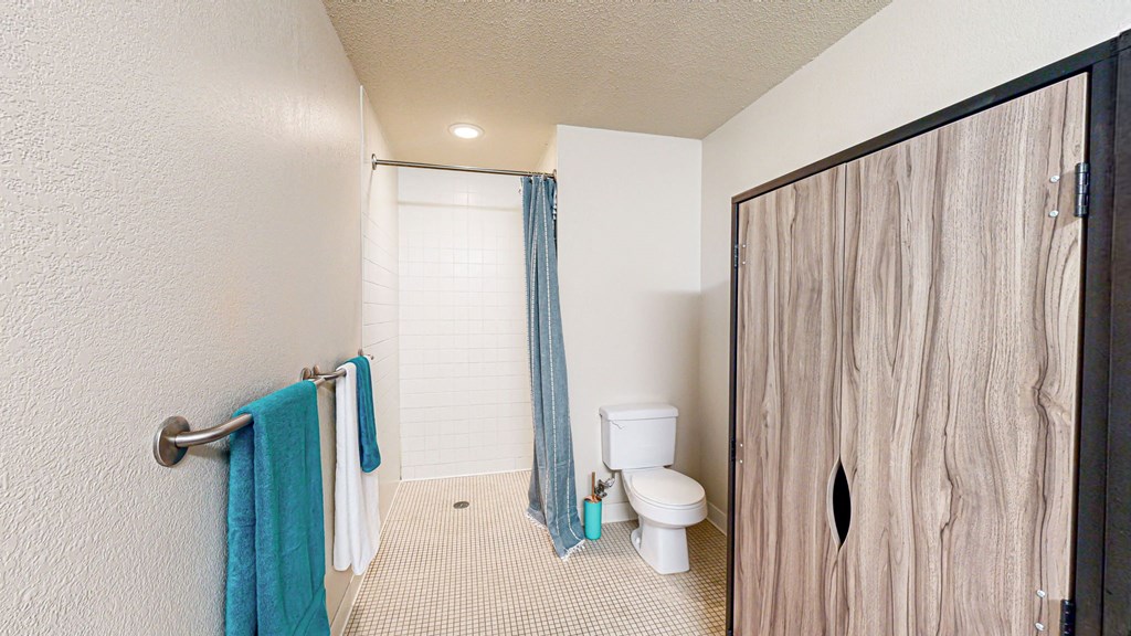 a bathroom with a toilet and a shower with a curtain at Bierman Place, Minneapolis, Minnesota