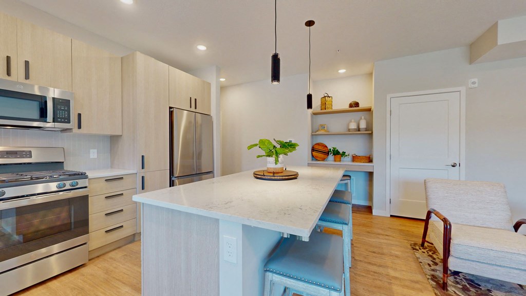 a kitchen with a large island and stainless steel appliances
