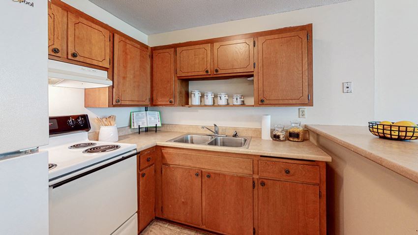 a kitchen with wooden cabinets and white appliances