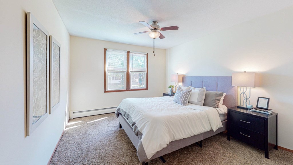 a bedroom with a bed and a ceiling fan